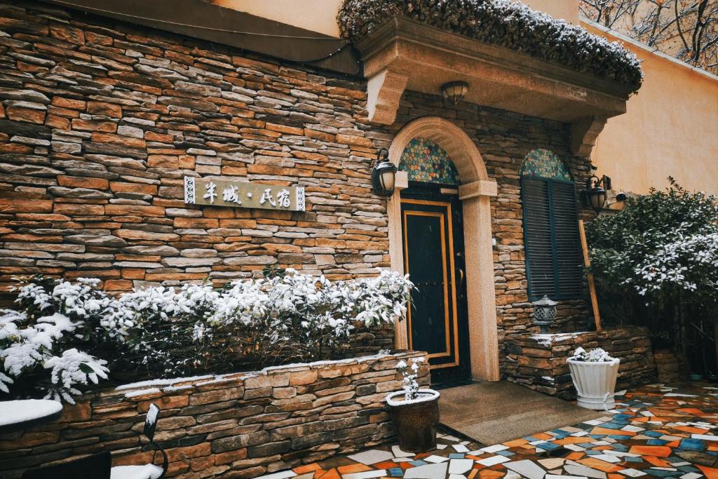 een gebouw met een stenen muur en een deur bij Half-City Homestay in Xi'an