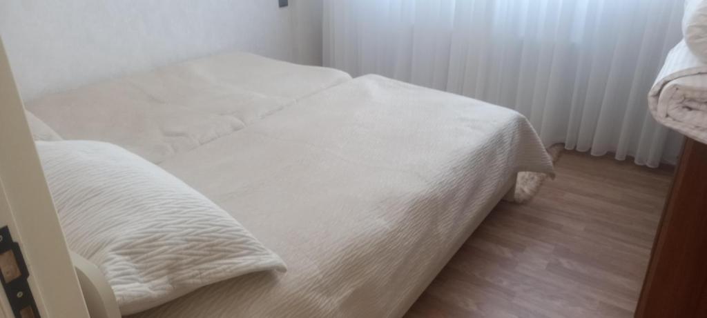 a bedroom with two beds with white sheets at Gusar Apartment in Qusar