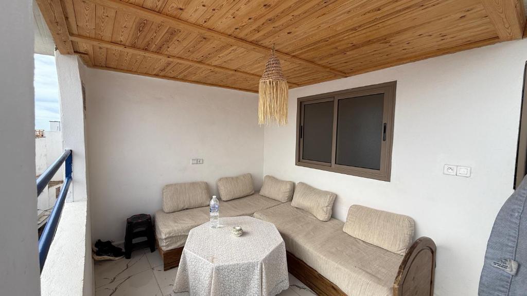 a living room with a couch and a table at Adar surf house in Taghazout