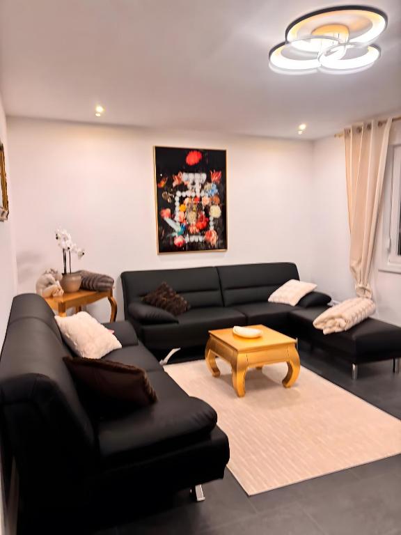 een woonkamer met twee zwarte banken en een tafel bij Ferienhaus Lopezan House, Living in Hornberg