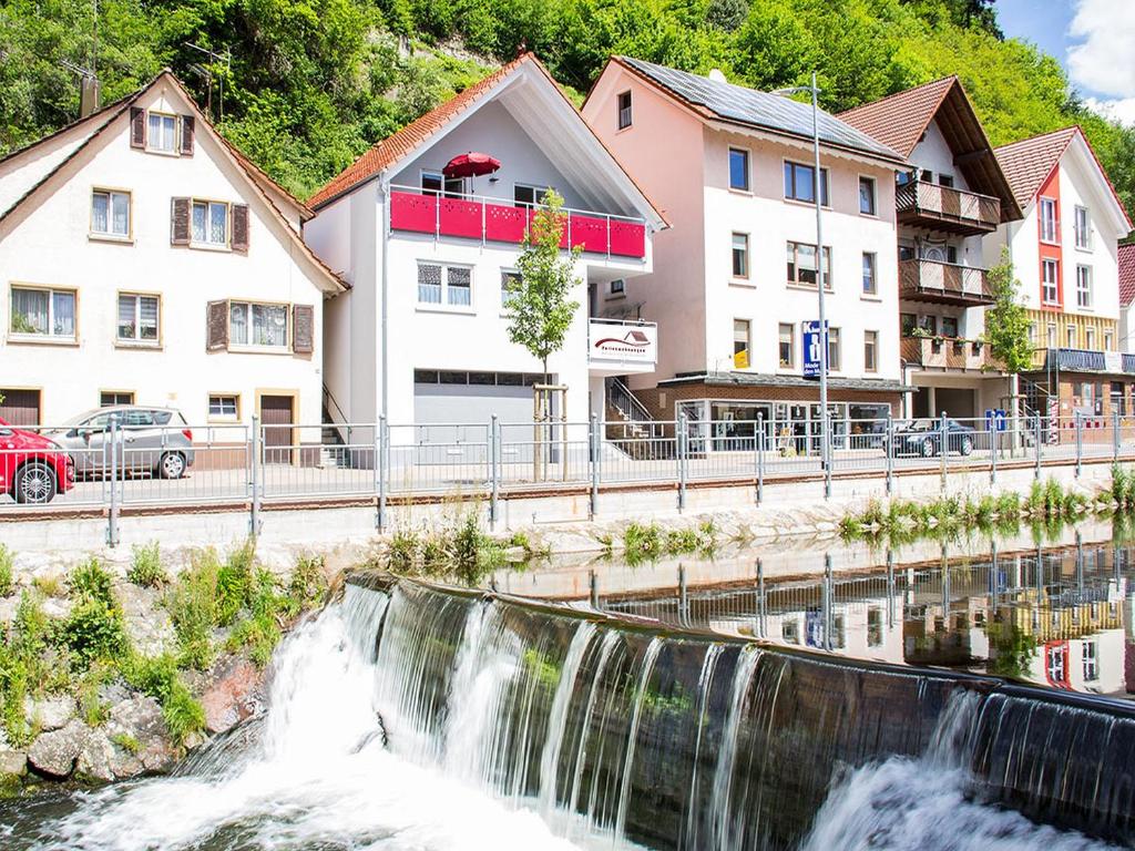 ein Wasserfall mitten in einer Stadt mit Häusern in der Unterkunft Ferienwohnungen Beilerstädtle in Oppenau