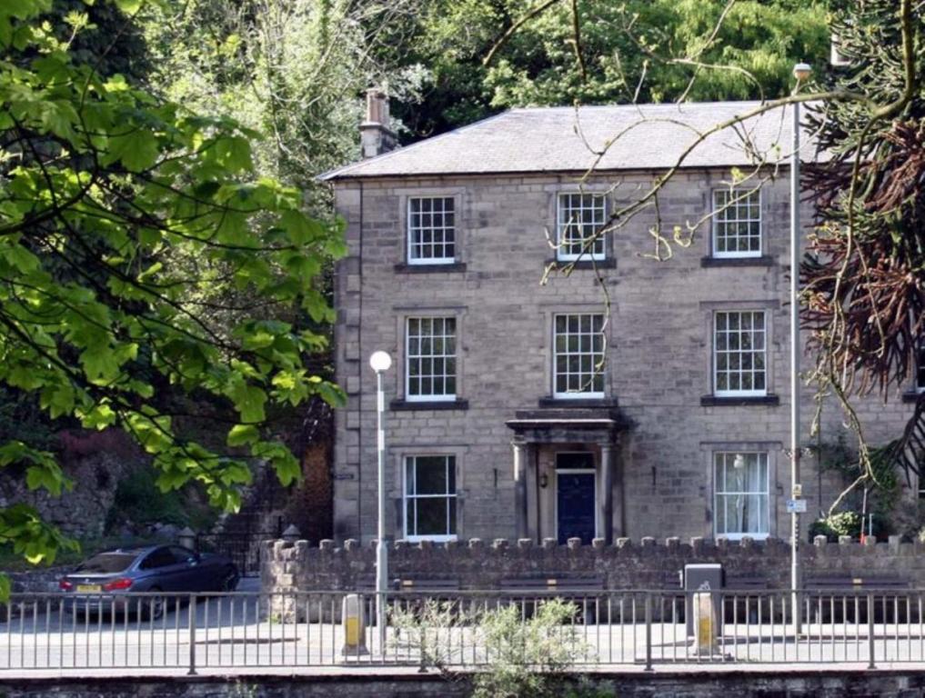 een oud stenen huis met een hek ervoor bij 7 Bed in Matlock Bath oc-n34368 in Cromford