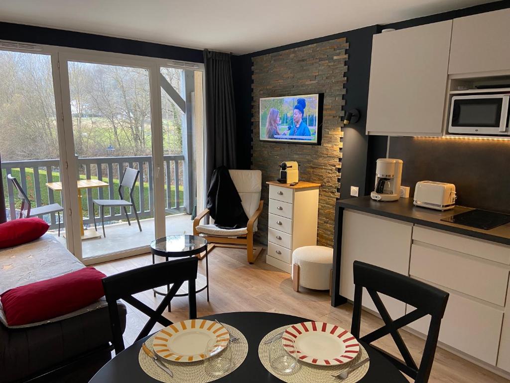 a kitchen and living room with a table and chairs at Appartement 203 in Saint-Lary-Soulan