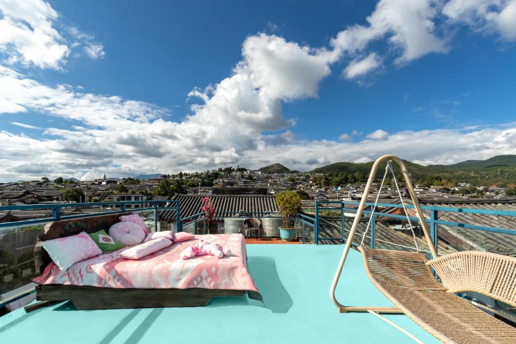 a bed on a balcony with a swing at 古城区瑾琳客栈 in Lijiang
