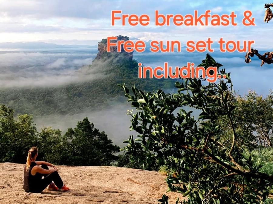 锡吉里亚The Travel Tree Hostel的一位女士坐在山顶上，旁边写着“免费早餐”和“免费”。