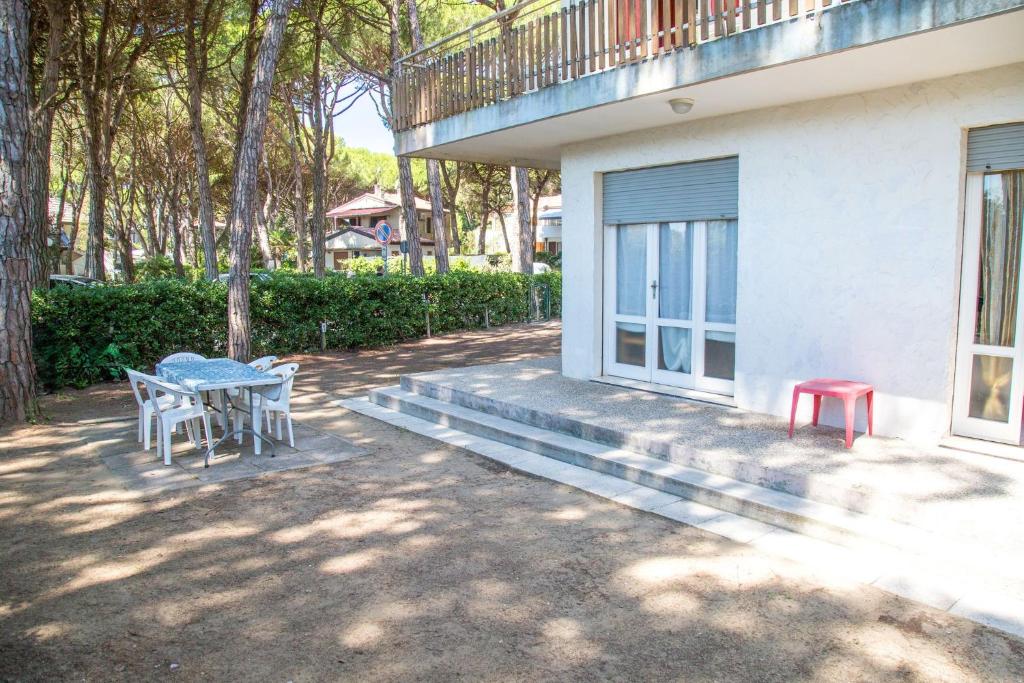 een tafel en stoelen buiten een huis bij Apartment in pine forest near the beach in Eraclea Mare
