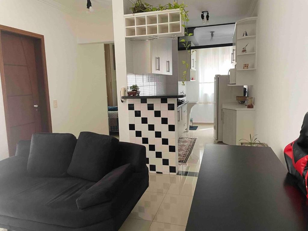 een woonkamer met een bank en een keuken bij Flat inteiro Indaiatuba in Indaiatuba