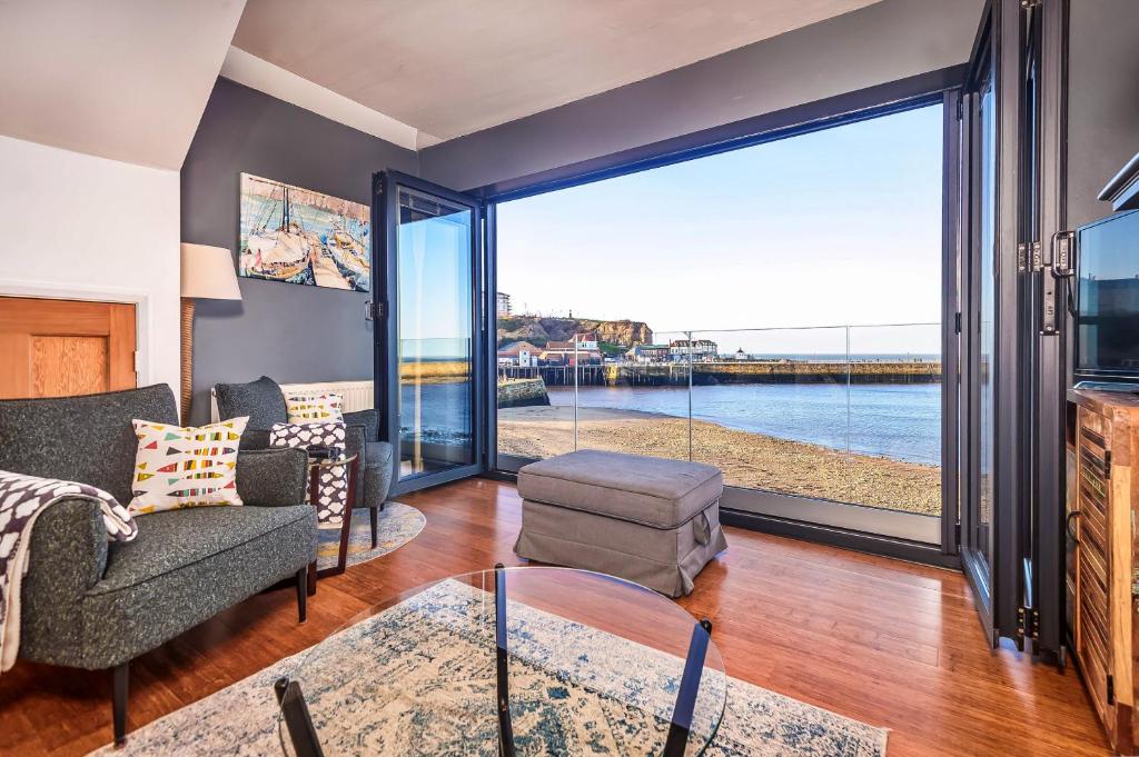 ein Wohnzimmer mit Blick aufs Wasser in der Unterkunft Finest Retreats - No 3 Sandside in Whitby