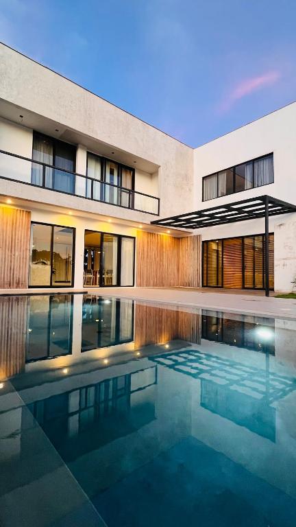 a house with a swimming pool in front of a building at Private pool villa Siargao La residence in General Luna
