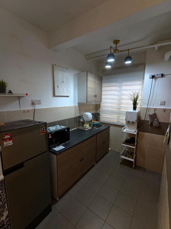 a kitchen with a sink and a stove top oven at Cocasa Homestay 1 in Kuala Terengganu