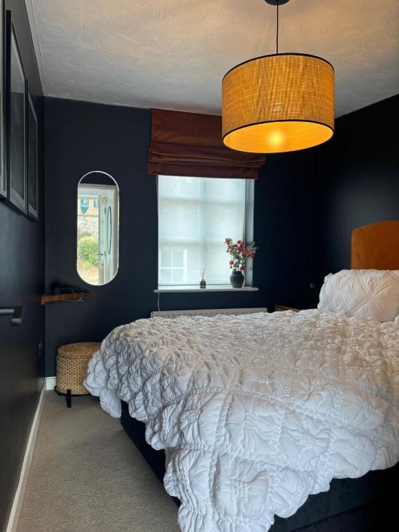 a bedroom with a white bed and a window at The Flower Loft in Yeovil