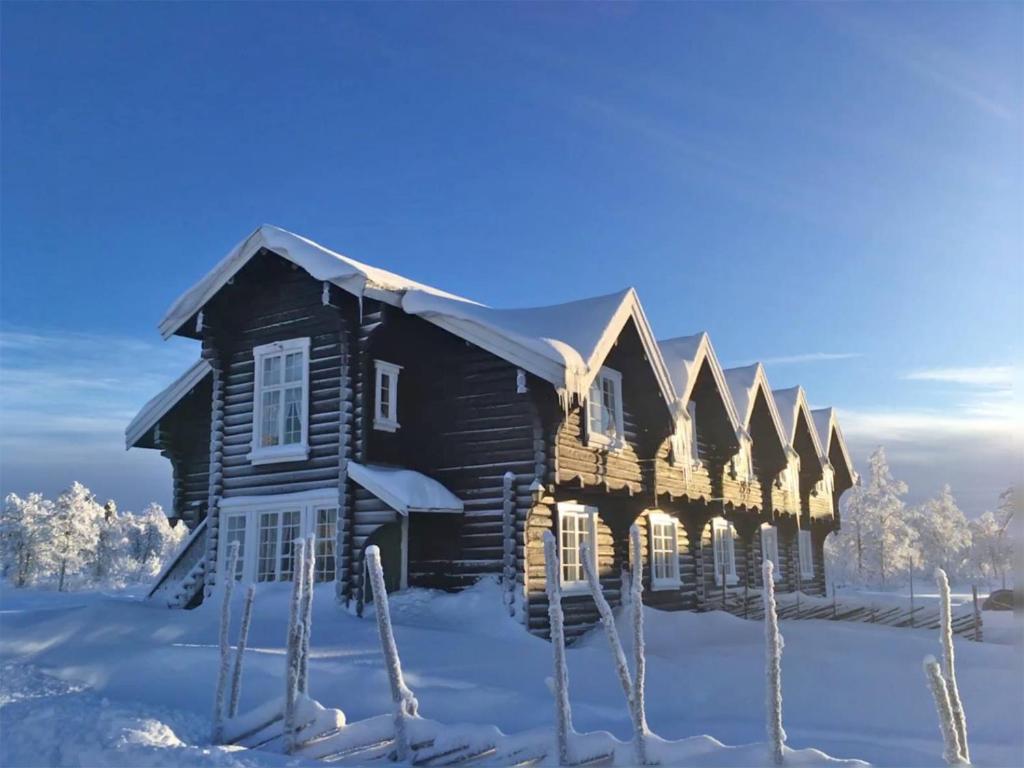 una casa in legno nella neve con la neve di Langleiken a Sør-Fron