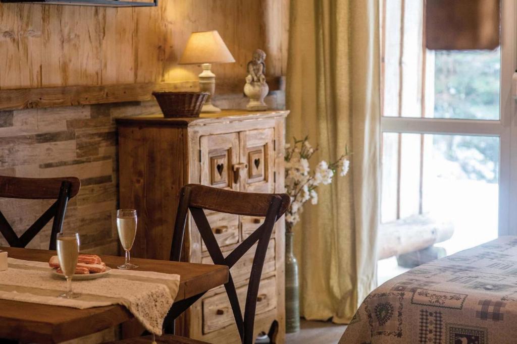 een eetkamer met een tafel met twee stoelen en een lamp bij Les Champis in La Bresse