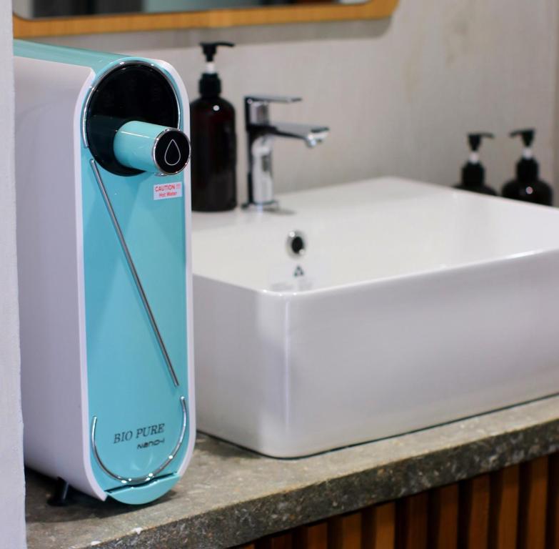 a hair dryer sitting on a counter next to a sink at Voyage Retreat Pulau Pangkor 归航楼 in Pasir Bogak