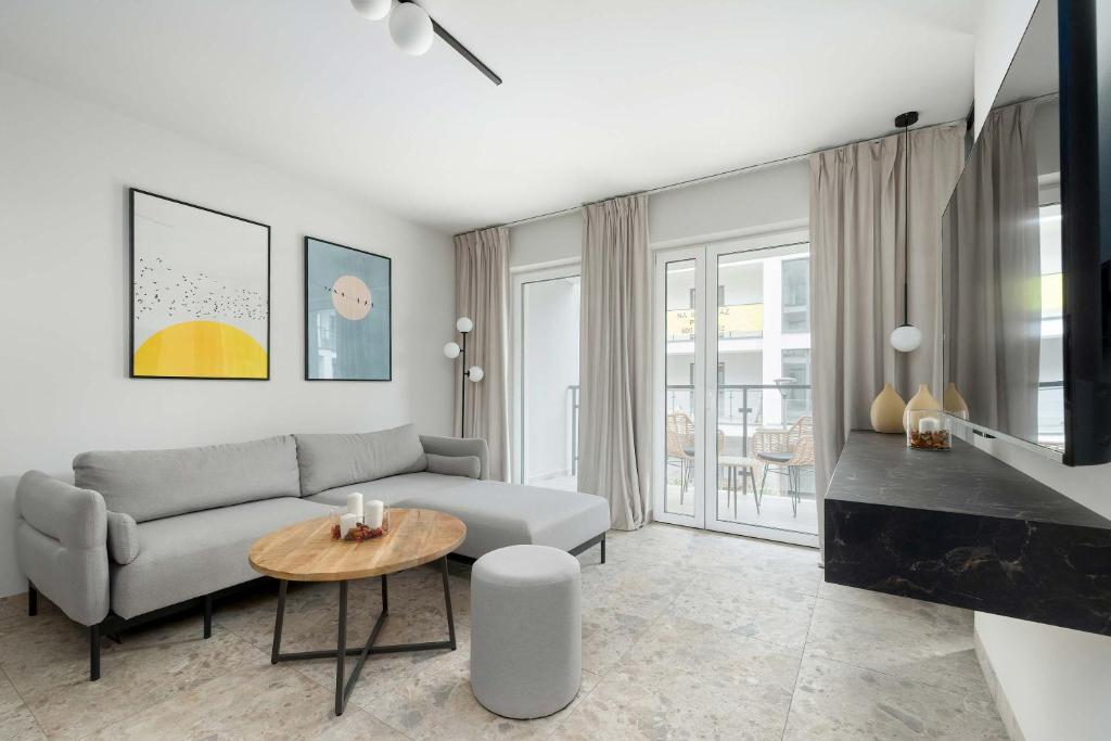 a living room with a couch and a table at Unique Studio with Parking Space and Swimming Pool by Noclegi Renters in Pobierowo