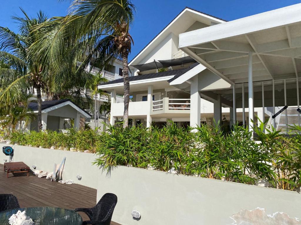 ein weißes Gebäude mit Palmen davor in der Unterkunft Villa del Mare - Waterfront Villa in Jan Thiel