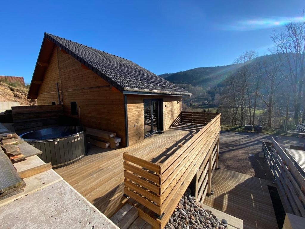 een huis met een terras met een hot tub bij Chalet Iris, spa privatif, 4p in Rochesson