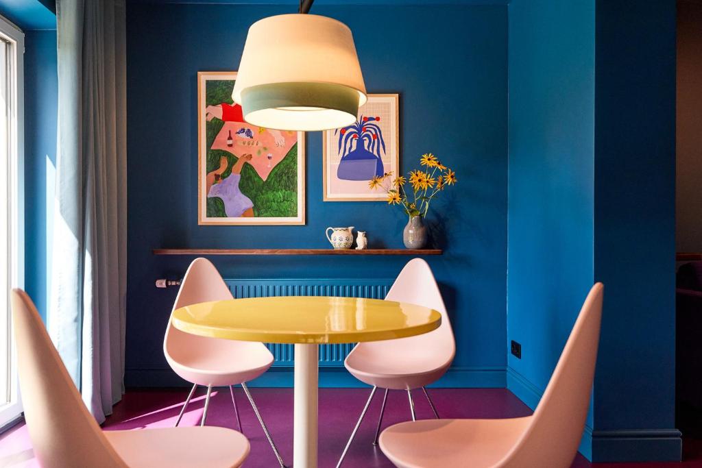a dining room with a yellow table and pink chairs at Appartementhaus Winter in Radstadt