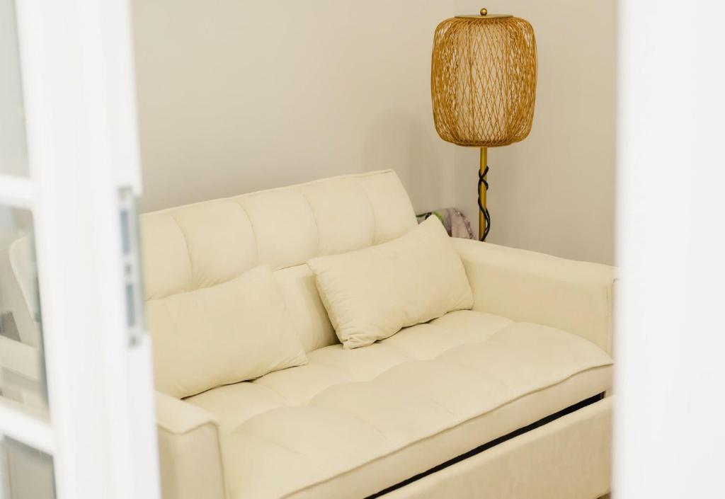 ein weißes Sofa im Wohnzimmer mit Lampe in der Unterkunft Le Chattok Villa in Bình Tú