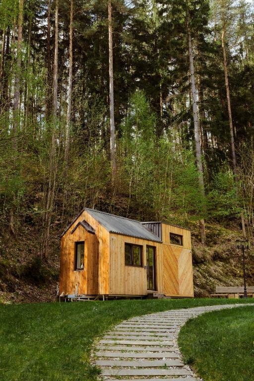 a small wooden house sitting on top of a field at Tiny house Malý gurmán in Rohozná