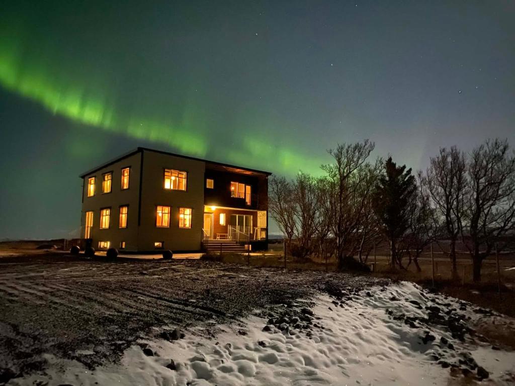 uma casa com as luzes do norte no céu em Syðri-Þverá em Hvammstangi
