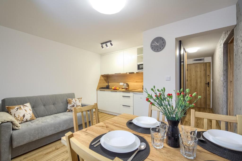 a living room with a table and a couch at Apartamenty Słoneczna in Tylicz