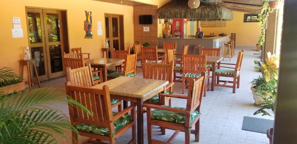 een restaurant met houten tafels en stoelen in een kamer bij Casa-Quiriri in Prado