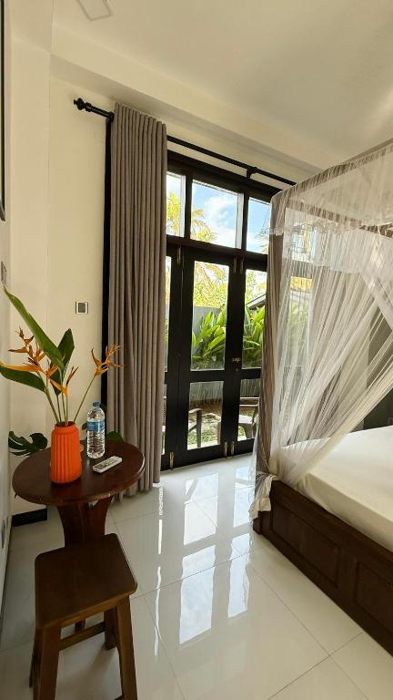 a bedroom with a bed and a table and a window at Priima in Ahangama