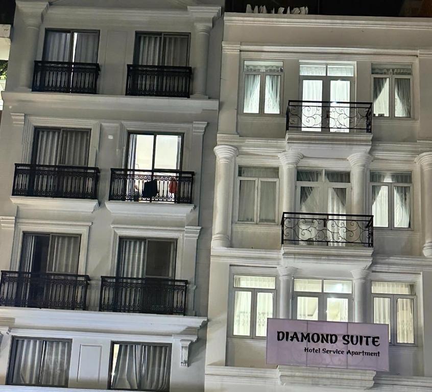 un edificio bianco con balconi e un cartello sopra di Diamond Suite Apartment ad Ho Chi Minh