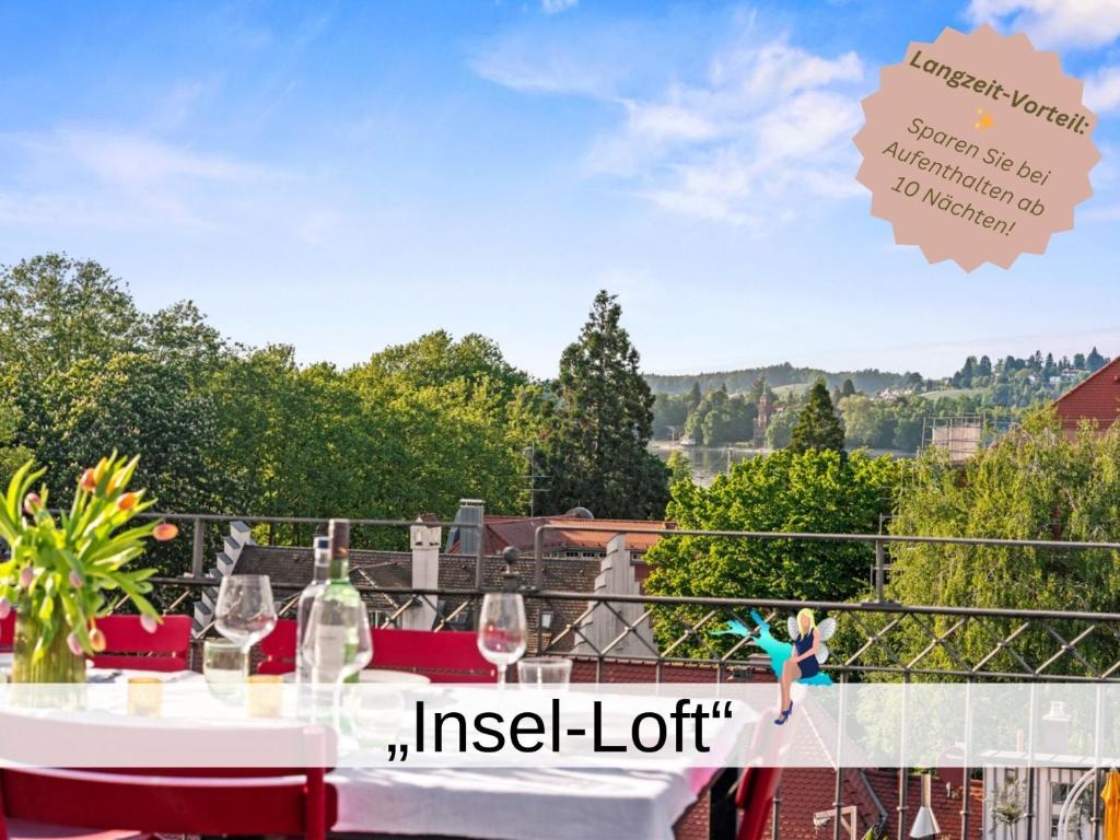 a woman dancing on a balcony with wine glasses at Ferienwohnung Insel-Loft - Maisonette auf der Insel, exklusiv mit Dachterrasse in Lindau