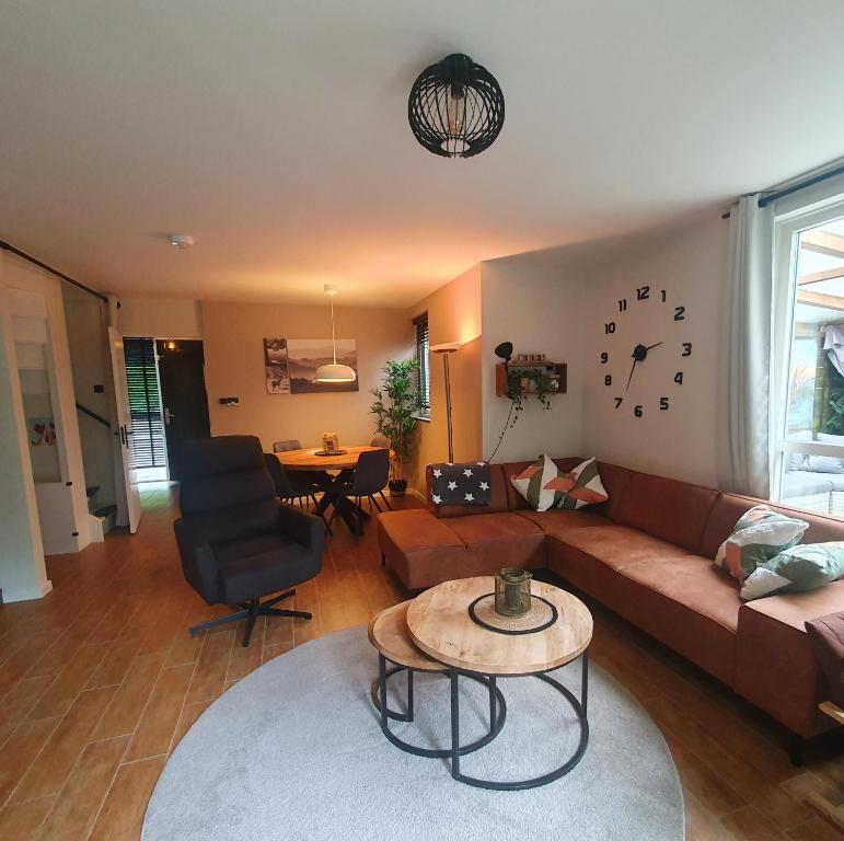 ein Wohnzimmer mit Sofa und Tisch in der Unterkunft 6 - Persoons Forest 217 Sauna Bungalow in Hernen