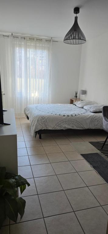 a bedroom with a bed and a tiled floor at Bed & Breakfast Illchirch in Illkirch-Graffenstaden