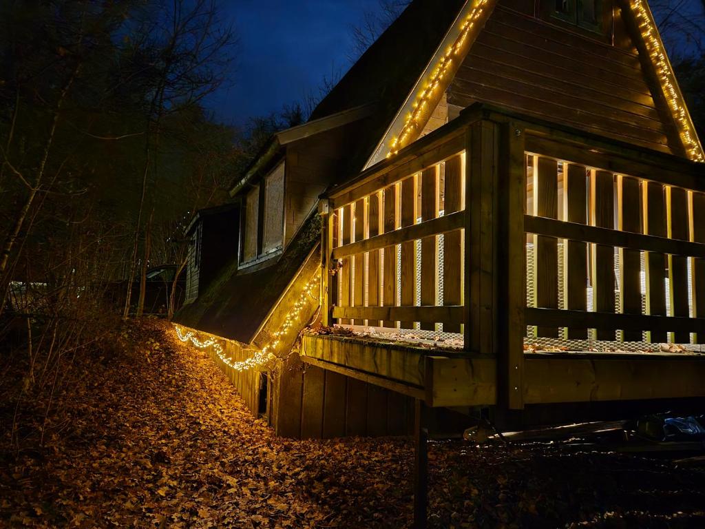 a house with christmas lights on the side of it at Chalet d Ooghe in Durbuy