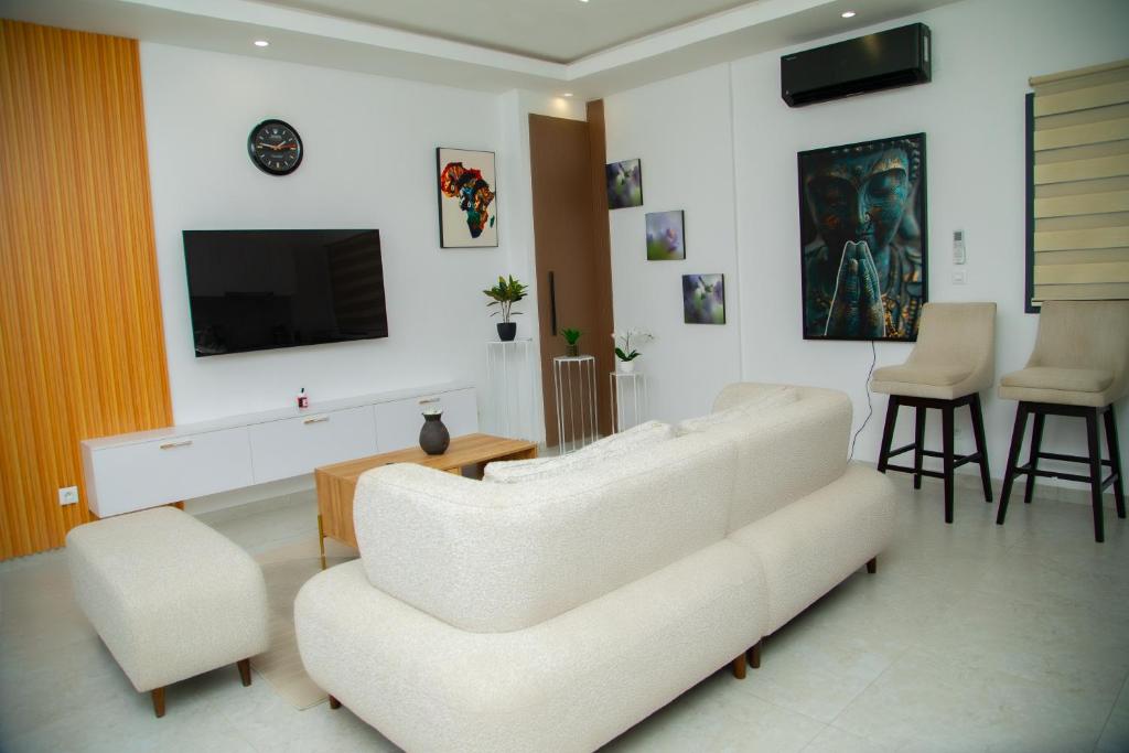 un soggiorno con un divano bianco e una TV di Appartement Neuf meublé de Haut Standing a Dakar