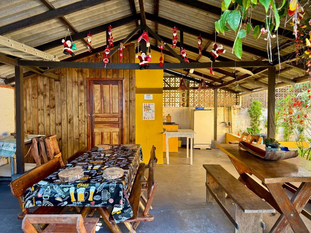 Zimmer mit einem Tisch und Bänken in einem Gebäude in der Unterkunft Solar das Andorinhas Pousada in Itapoa