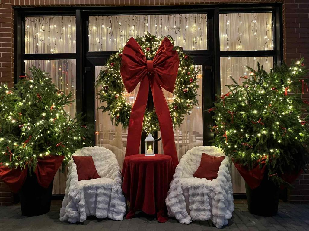 帕兰加Labas Rytas Vila的房间里有两把椅子、一张桌子和几棵圣诞树。