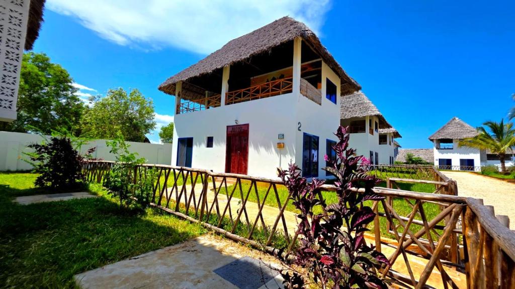 una piccola casa bianca con tetto di paglia di COCO JAMBO PARADISE Resort a Uroa