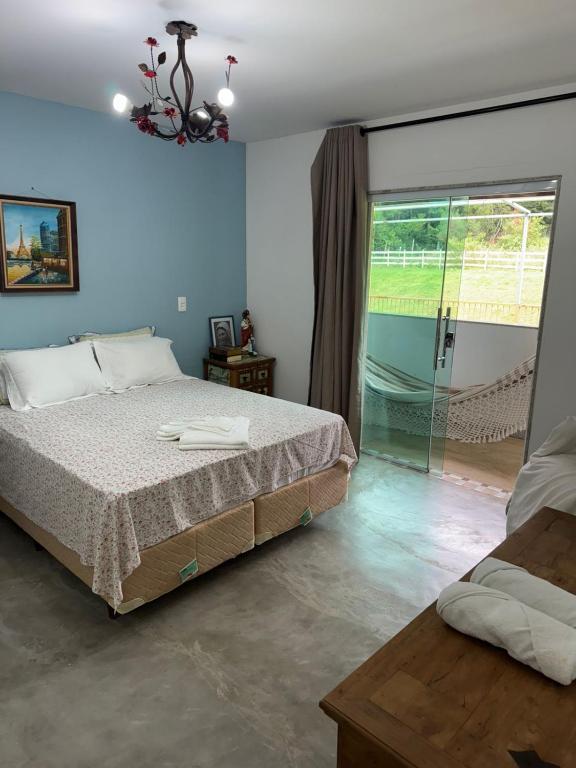 瓜拉派瑞Pousada Villa Felicidade的一间卧室，里面有一张床和一扇推拉玻璃门