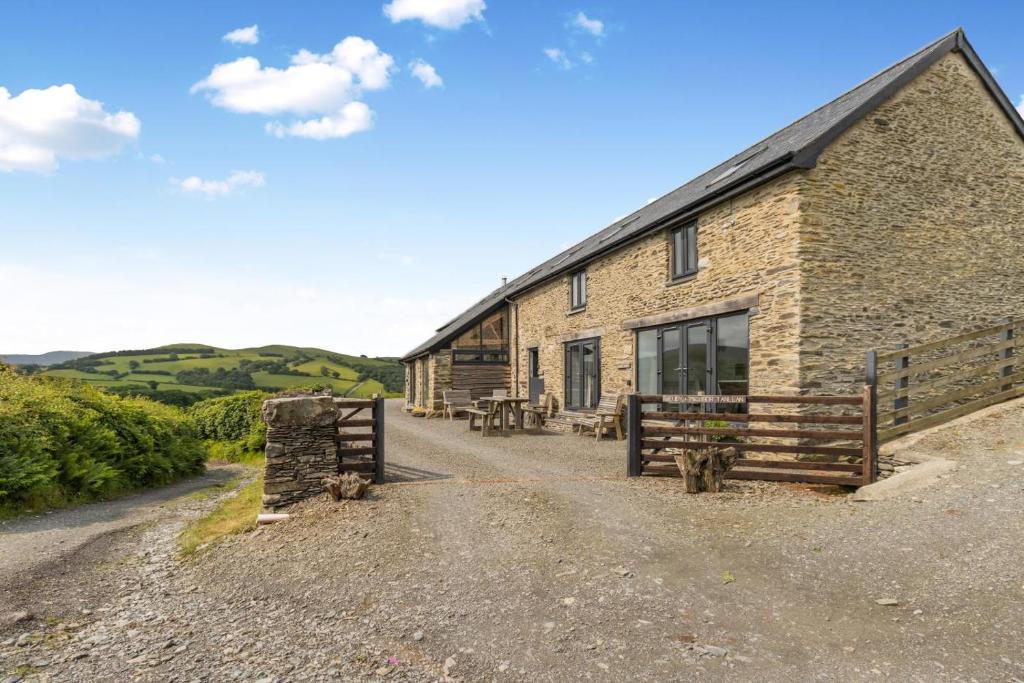 a stone building with benches in front of it at 3 Bed in Machynlleth oc-bow40 in Darowen