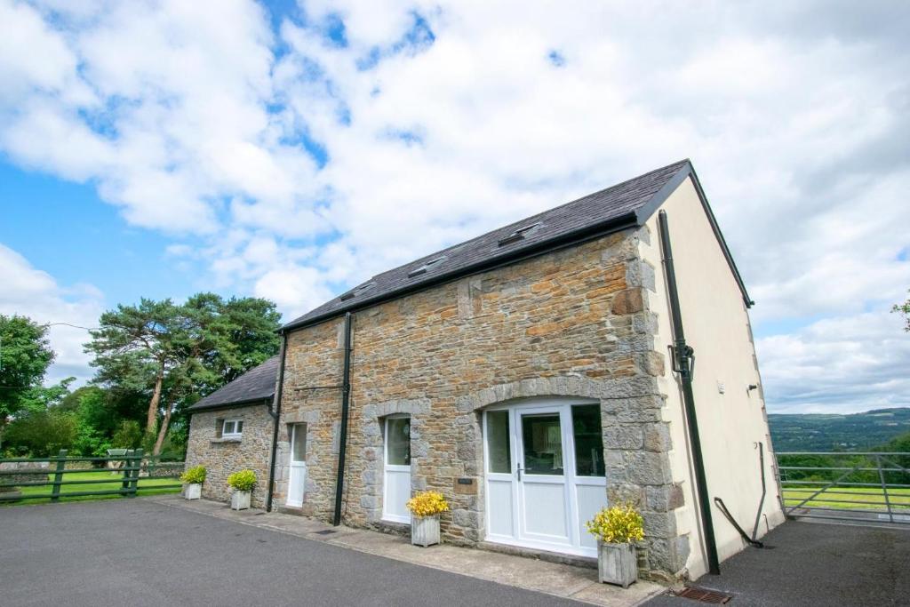 een klein bakstenen gebouw met witte deuren en bloemen bij 3 Bed in Swansea Valley oc-80031 in Pontardawe