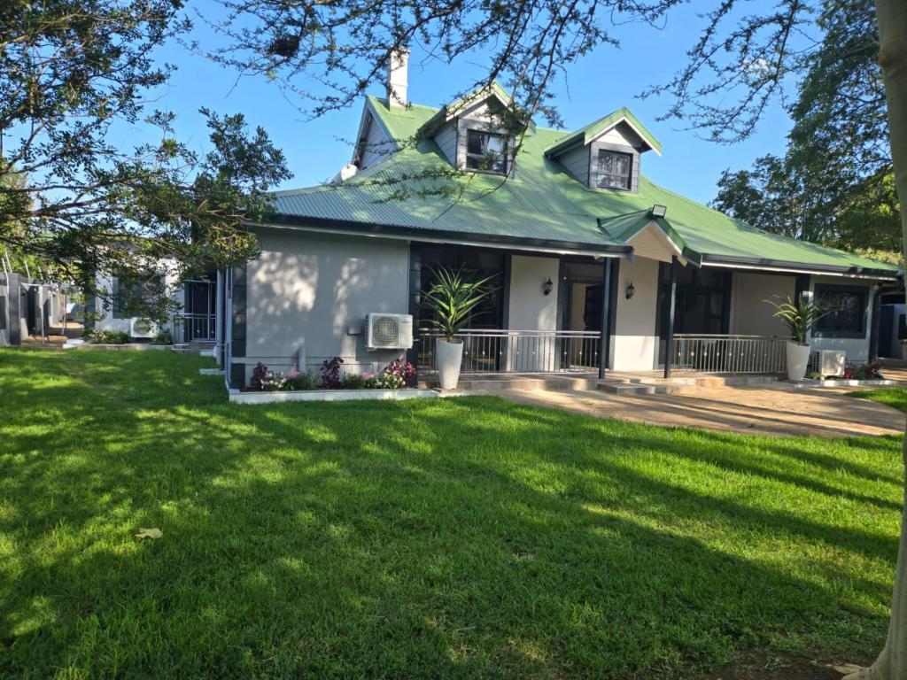 彼得马里茨堡The Corner Guesthouse的一座带绿色屋顶和庭院的房子