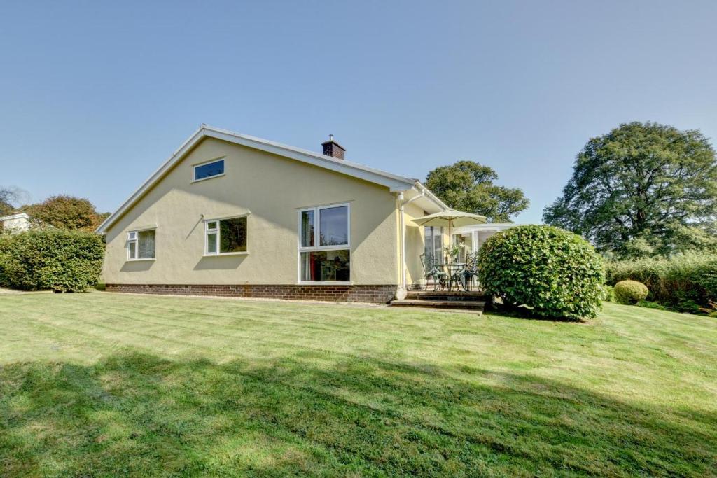 a house with a large grassy yard in front of it at 2 Bed in Dulverton oc-badger in Dulverton