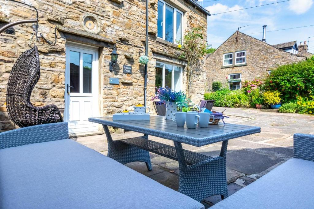 Ein blauer Tisch und Stühle vor einem Steinhaus in der Unterkunft 3 Bed in Askrigg oc-ds1035 in Askrigg