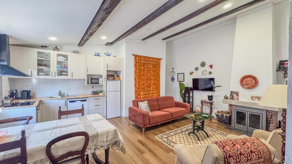 Una cocina y una sala de estar con mesa y sillas. en Ninho do Melro II - Turismo Rural Bragança, en Bragança