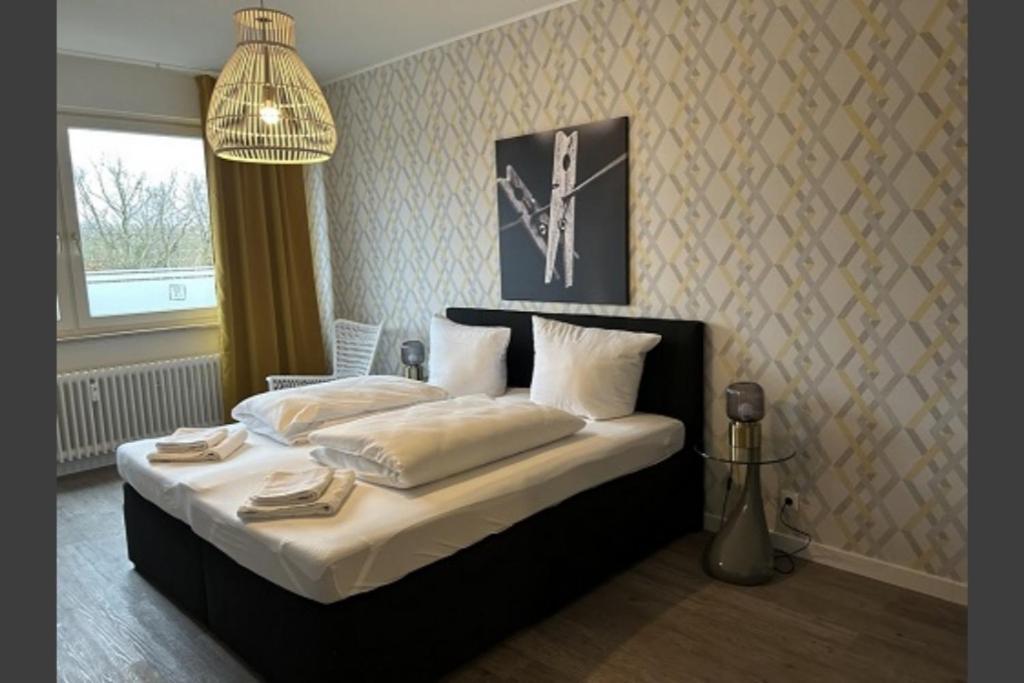a bedroom with a bed with white sheets and pillows at Günstige Ferienwohnung 2 Pers zentral Hamburg BoLA 48 in Hamburg