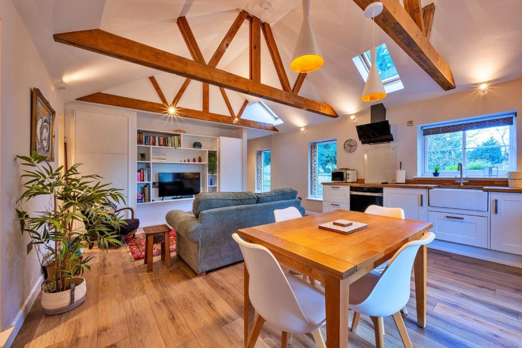 a kitchen and living room with a wooden table and chairs at Finest Retreats - The Asparagus Shed in Howell