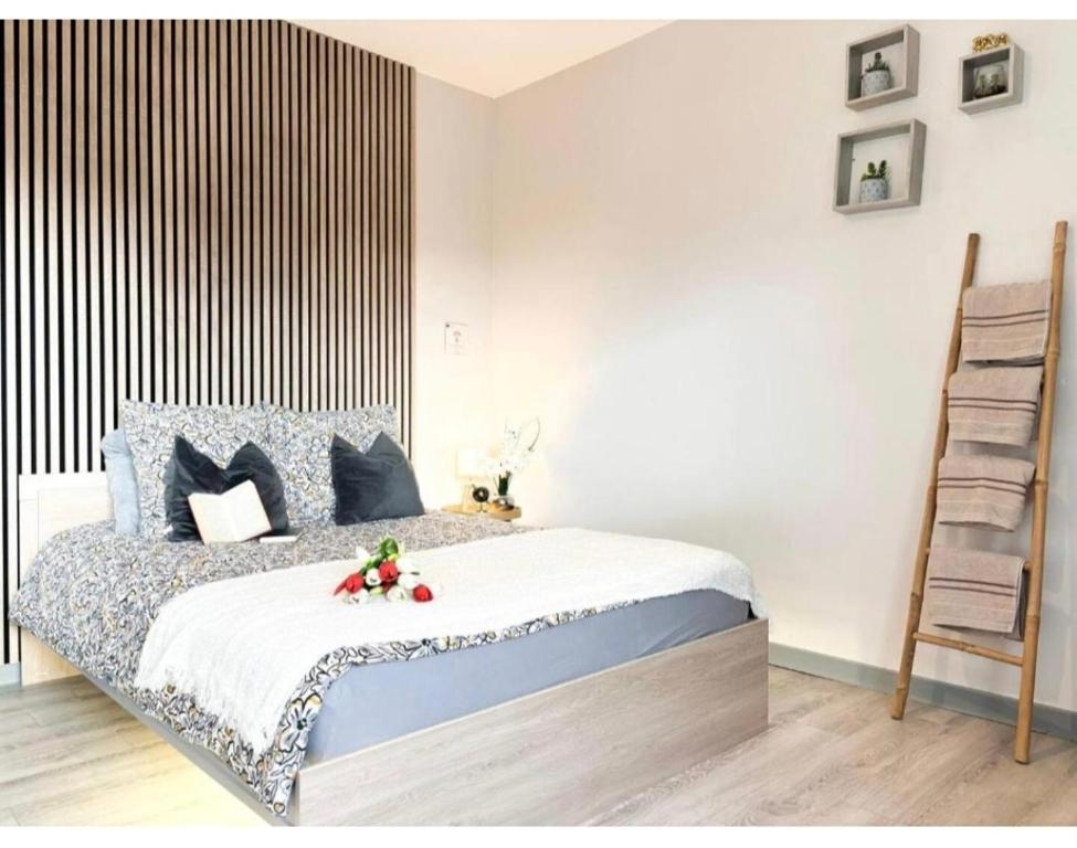 a bedroom with a bed and a wooden ladder at Central Studio - Proche Bâle & St Louis in Saint-Louis