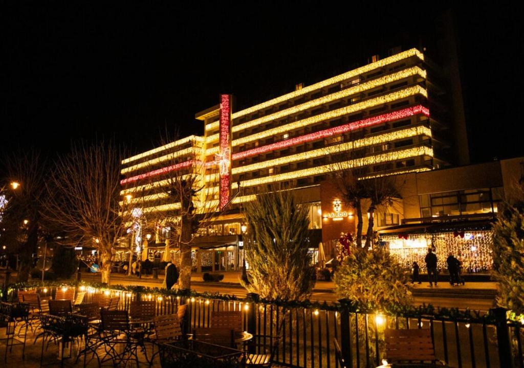 a large building with lights on it at night at Hotel Sinaia in Sinaia