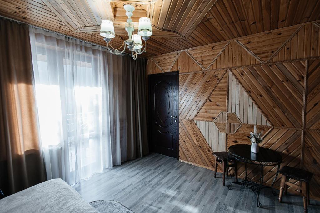a room with a wooden wall with a table in it at Sadyba u Halyny in Bukovel