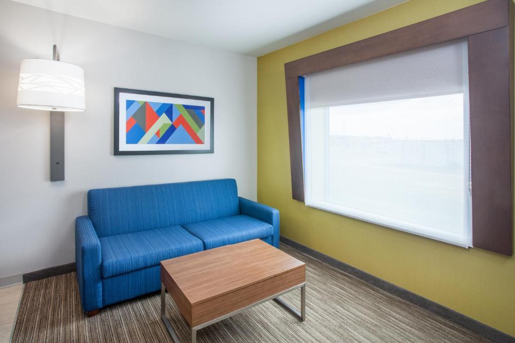a waiting room with a blue couch and a window at Holiday Inn Express & Suites Texarkana by IHG in Texarkana